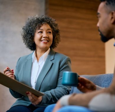 Happy female insurance agent advising African American client during a meeting in the office.